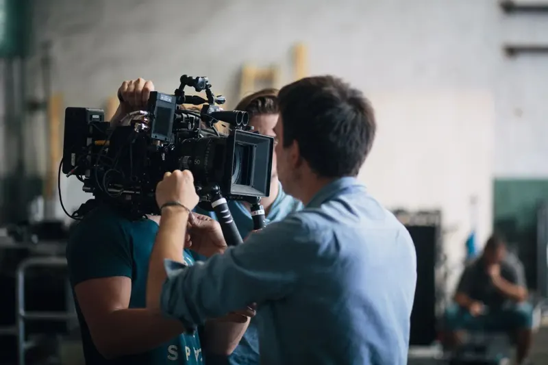 Production crew adjusting a professional video camera on set