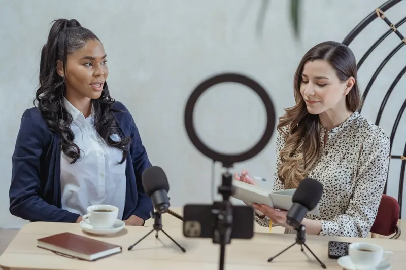 Two women recording a microphone interview